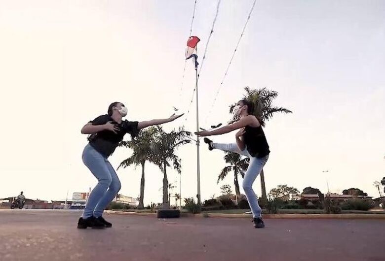 Bailarinas dançam na fronteira separadas por arame farpado