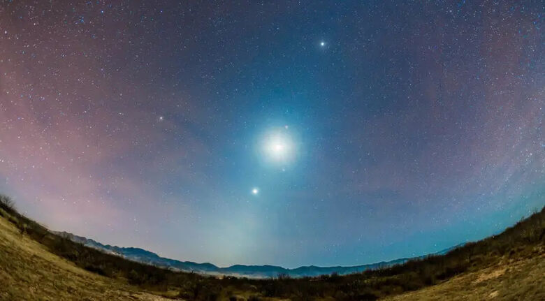 O objeto mais brilhante no céu noturno, a lua é mostrada ladeada por três planetas: Vênus (abaixo); Marte, logo acima da lua; e Júpiter (topo) - Crédito: Alan Dyer/VWPics/Universal Images Group/Getty Images