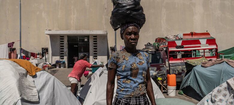Uma mulher recém-deslocada no Gymnasium Vincent, um complexo escolar e esportivo no centro de Porto Príncipe - Crédito: Ocha/Giles Clark