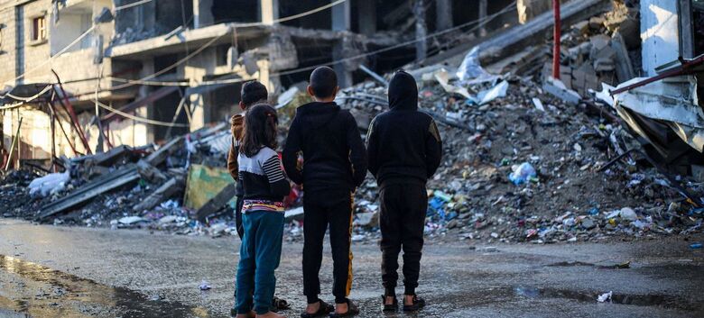 Crianças diante de uma casa demolida por um bombardeio na cidade de Rafah, ao sul da Faixa de Gaza - Crédito: Unicef/Eyad El Baba
