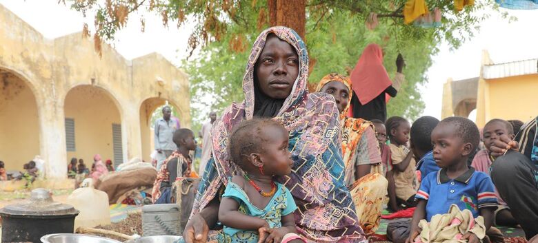Mariam Djimé Adam, 33 anos, está sentada no pátio da escola secundária de Adre, no Chade. Ela chegou do Sudão com seus 8 filhos. "Fomos atacados em nossa casa, meu marido foi morto e todos os nossos pertences foram levados. Consegui fugir com meus filhos" - Crédito: Unicef/Mahamat
