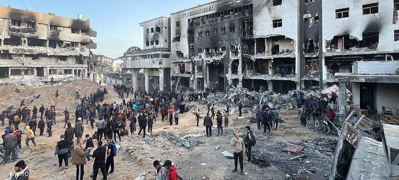 Pessoas se reúnem em frente às ruínas do hospital Al Shifa, o maior centro de saúde de Gaza - Crédito: OMS