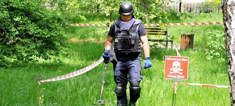 Um desminador do Serviço Estatal de Emergência da Ucrânia varre o terreno em busca de munições não detonadas e minas terrestres - Crédito: PNUD Ucrânia/Oleksandr Simonenko
