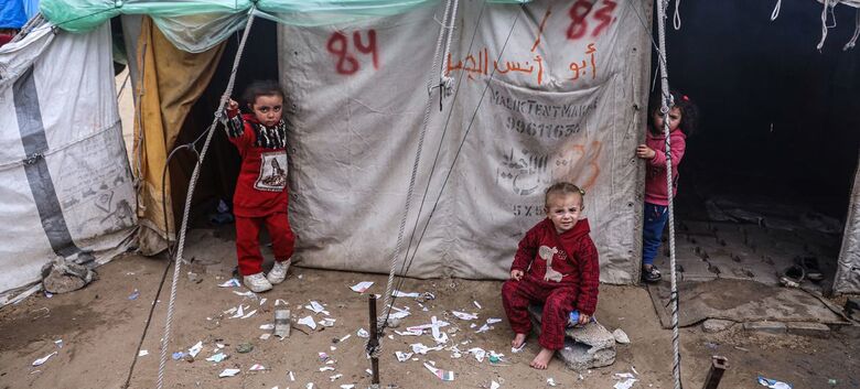 Crianças do lado de fora de seu abrigo temporário em Rafah, no sul da Faixa de Gaza - Crédito:  WHO