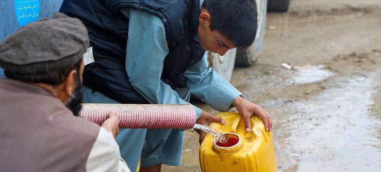 Pessoas na região central do Afeganistão coletam água de caminhão depois que suas casas foram levadas pelas enchentes - Crédito:  UNICEF/Hasinullah Qayoumi 