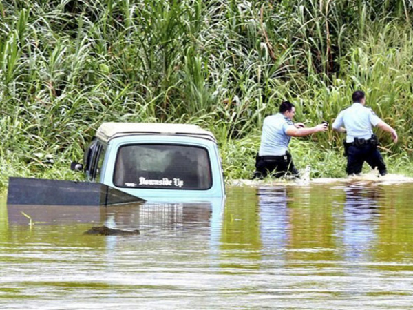 Policiais procuram por vítimas das chuvas em Queensland. - Crédito: Foto: AP Photo/Queensland Police