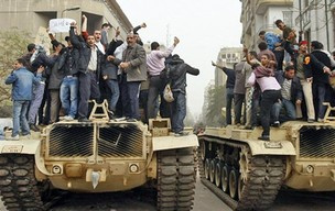Manifestantes egípcios exigindo a derrubada do
presidente Hosni Mubarak em cima de tanques do
exército egípcio no Cairo - Crédito: Foto: M. Abed/AFP