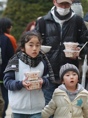 Família evacuada de Miyagi recebe arroz e carne
saudáveis para comer. - Crédito: Foto: Jiji Press / AFP Photo