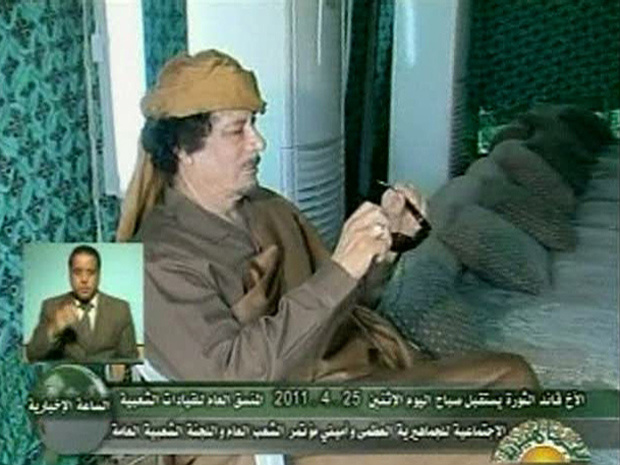 O ditador da Líbia, Muammar Kadhafi, olha para seus óculos escuros em imagem mostrada nesta segunda-feira - Crédito: Foto: Reuters