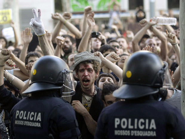 Policiais de choque contêm manifestantes em frente ao Parlamento da Catalunha, nesta quarta-feira - Crédito: Foto: AP