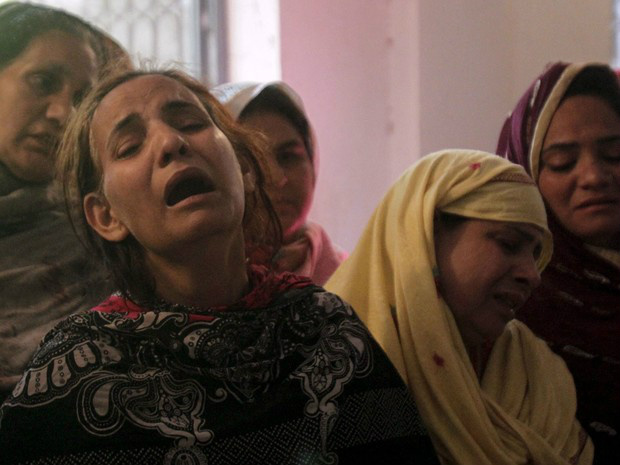 Familiares choram a morte de vítima de ataque perto de parquet em Lahore, no Paquistão, que aconteceu no domingo - Crédito: 27